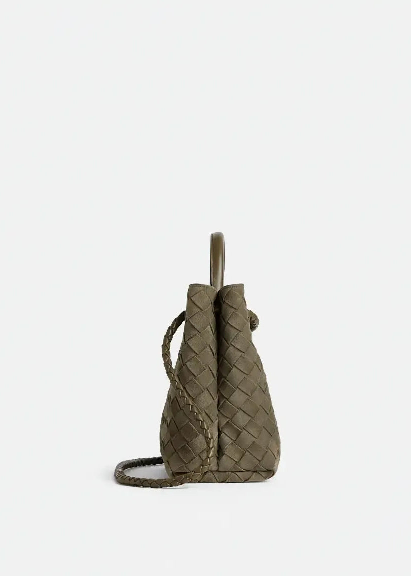 Woven green handbag on a white background