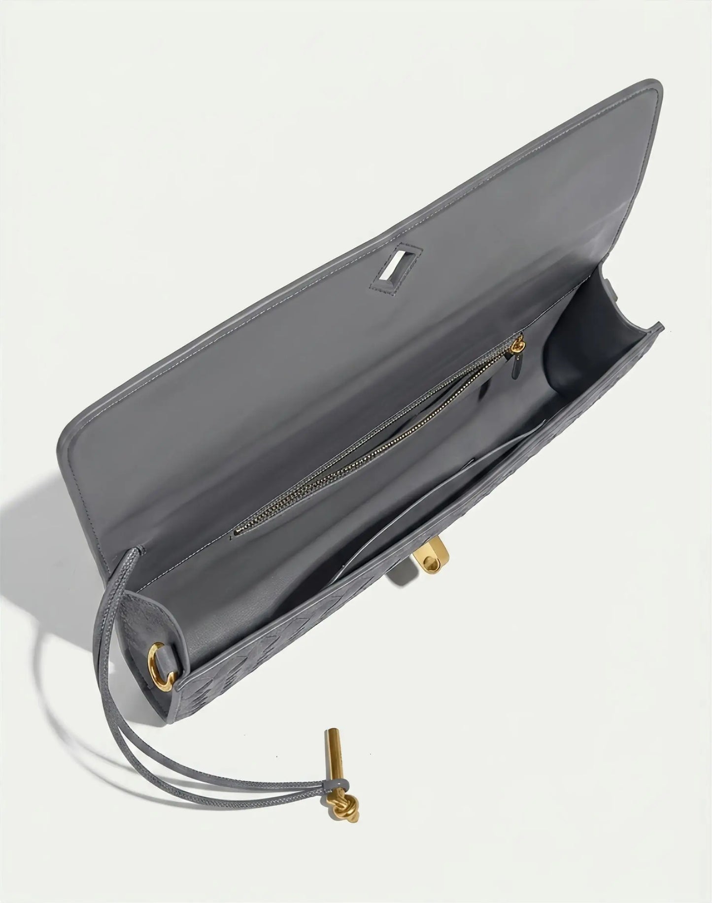 Gray handbag with gold accents on a light gray background