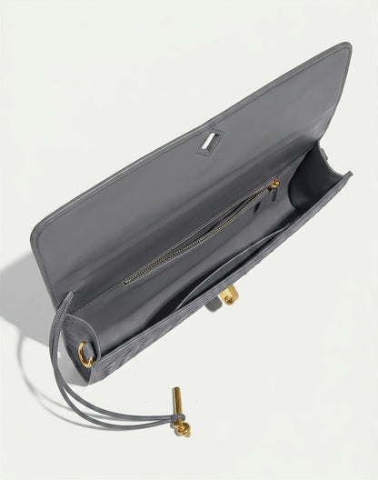 Gray handbag with gold accents on a light gray background
