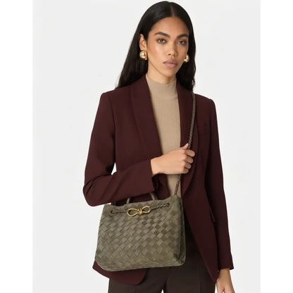 Woman holding a patterned handbag against a plain background
