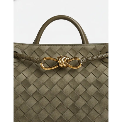 Green woven handbag with a gold clasp on a white background