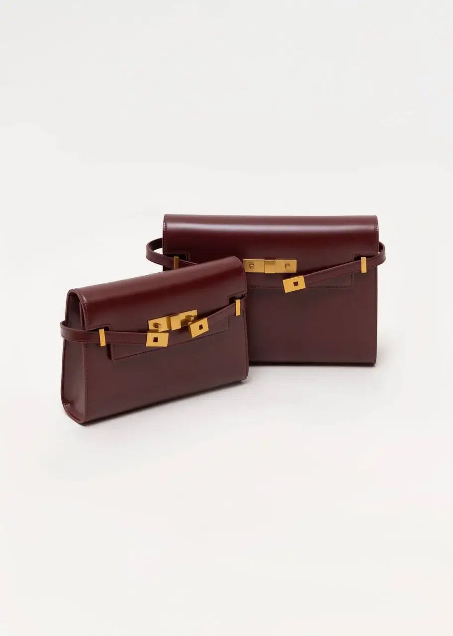 Two brown leather handbags with gold hardware on a white background